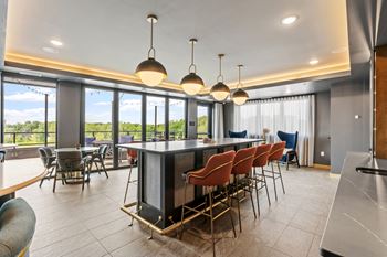 A modern kitchen with a bar area and chairs.